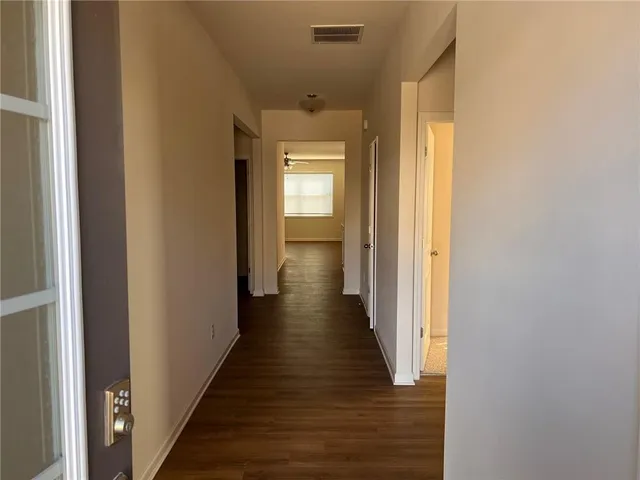 a view of a hallway with wooden floor