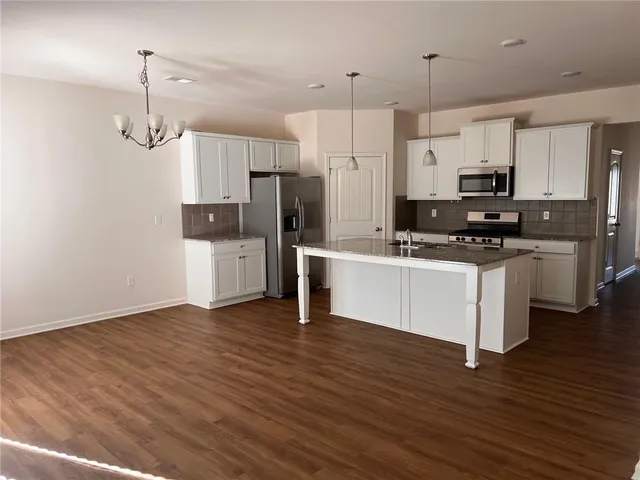 a kitchen with stainless steel appliances a refrigerator sink and microwave