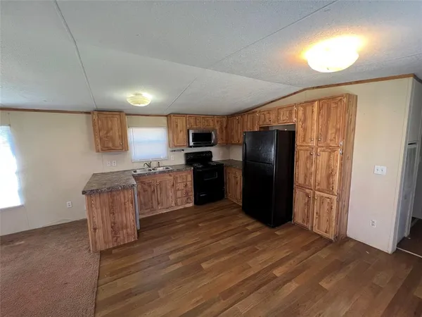 a kitchen with granite countertop stainless steel appliances refrigerator and cabinets