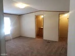 an empty room with closet and windows