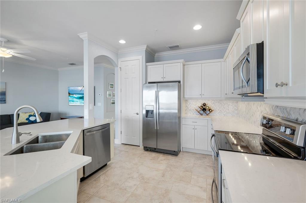 9060 Siesta Bay Drive, Unit 101 Naples, FL 34120 - Photo 12 of 49 a kitchen with stainless steel appliances granite countertop a sink and a refrigerator