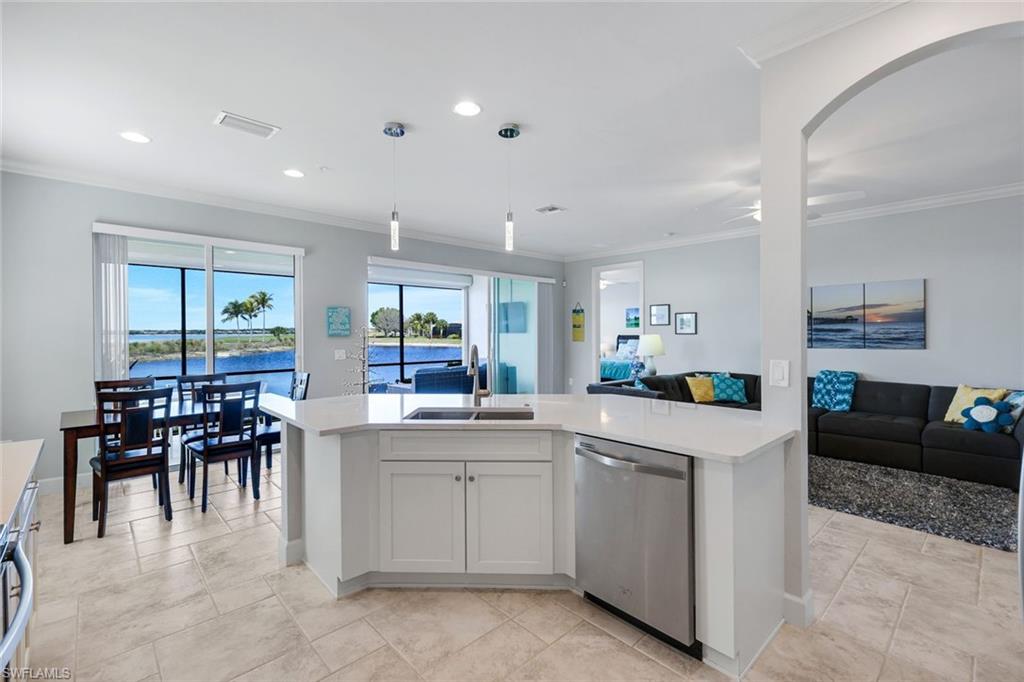 9060 Siesta Bay Drive, Unit 101 Naples, FL 34120 - Photo 13 of 49 a kitchen with a sink and chairs