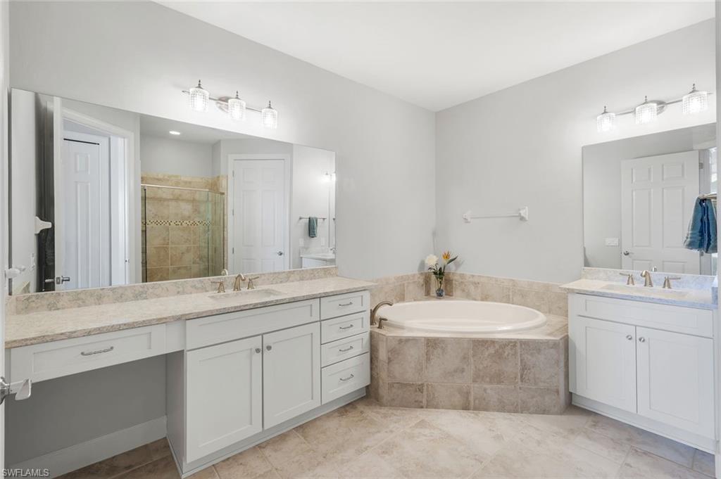 9060 Siesta Bay Drive, Unit 101 Naples, FL 34120 - Photo 24 of 49 a bathroom with a double vanity sink mirror and bathtub