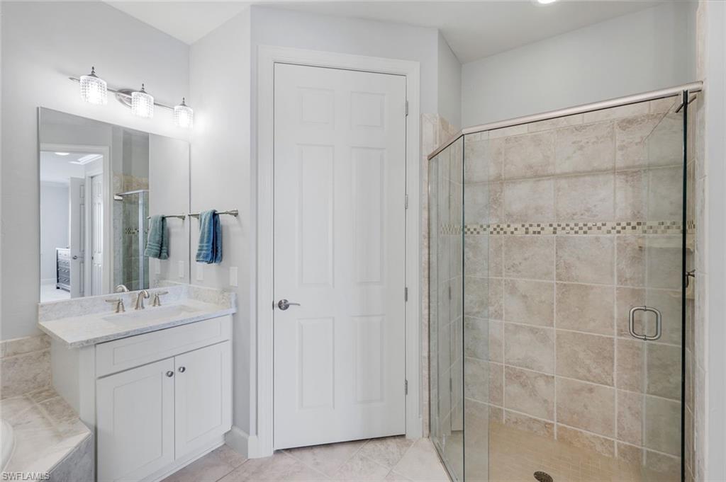 9060 Siesta Bay Drive, Unit 101 Naples, FL 34120 - Photo 25 of 49 a bathroom with a double vanity sink mirror and shower