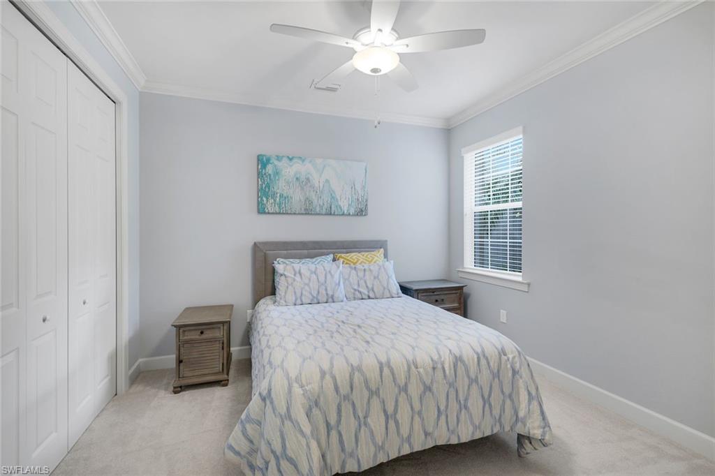 9060 Siesta Bay Drive, Unit 101 Naples, FL 34120 - Photo 26 of 49 a bedroom with a bed and a chandelier