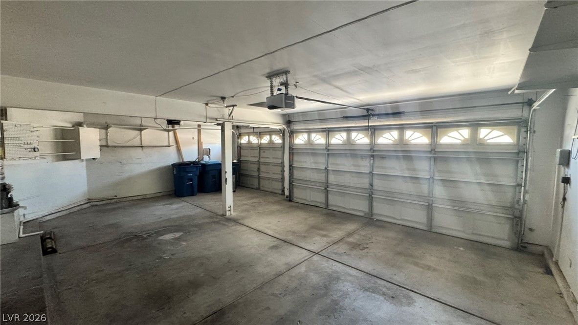 9716 Ridge Creek Place Las Vegas, NV 89134 - Photo 26 of 28 An empty garage with concrete flooring and ample storage space awaits customization.