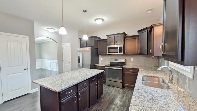 a kitchen with stainless steel appliances granite countertop a sink stove and refrigerator