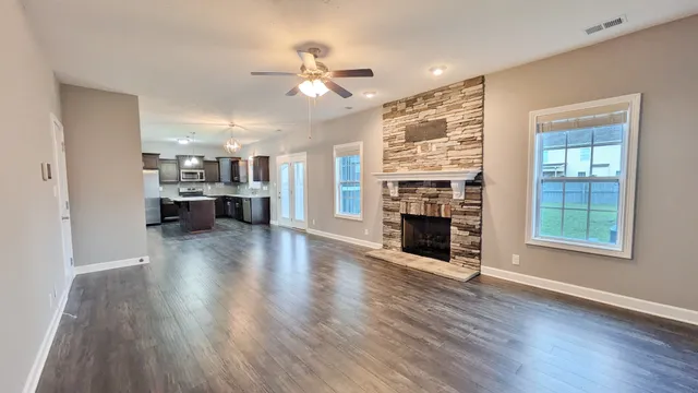 wooden floor fireplace and windows in an empty room