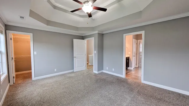 an empty room with closet and a ceiling fan