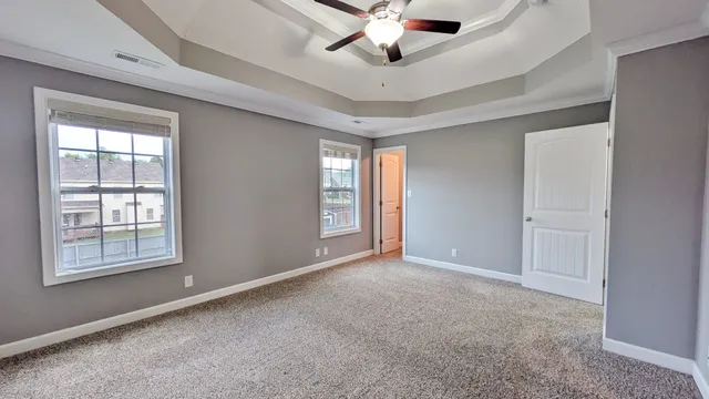 an empty room with windows and fan