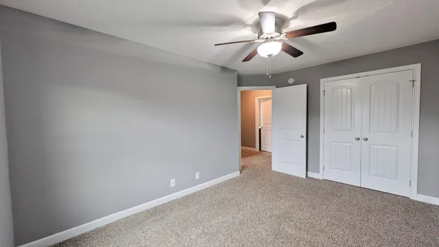 wooden floor in an empty room and a ceiling fan