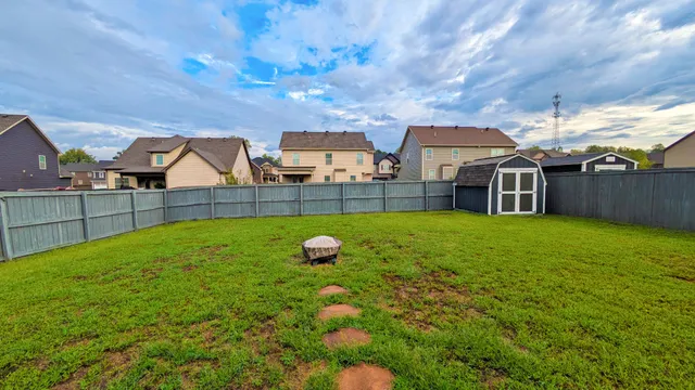 a view of a house with backyard and sitting area