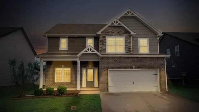 a front view of a house with a yard and trees