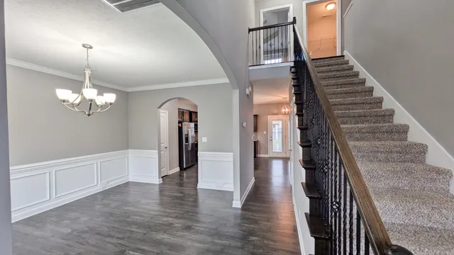a view of a hallway with wooden floor and staircase