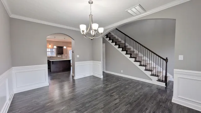 a view of a livingroom with wooden floor and staircase