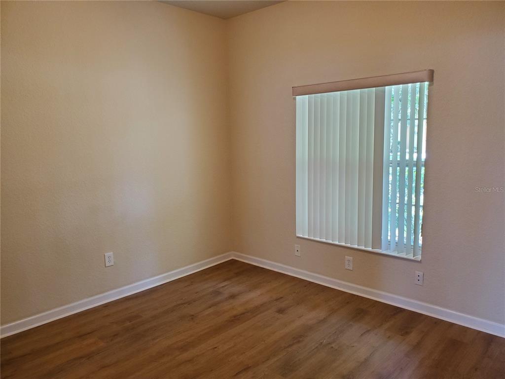 5584 Southwest 39th Street Ocala, FL 34474 - Photo 13 of 56 an empty room with wooden floor and windows