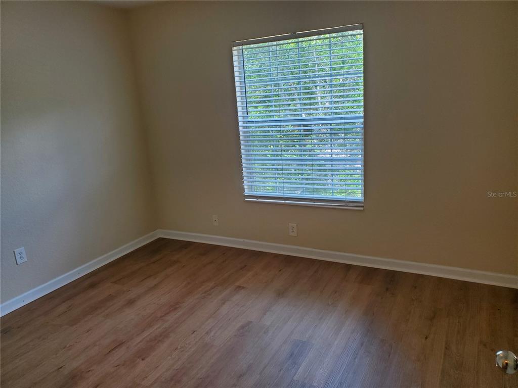 5584 Southwest 39th Street Ocala, FL 34474 - Photo 16 of 56 a view of an empty room with wooden floor and a window