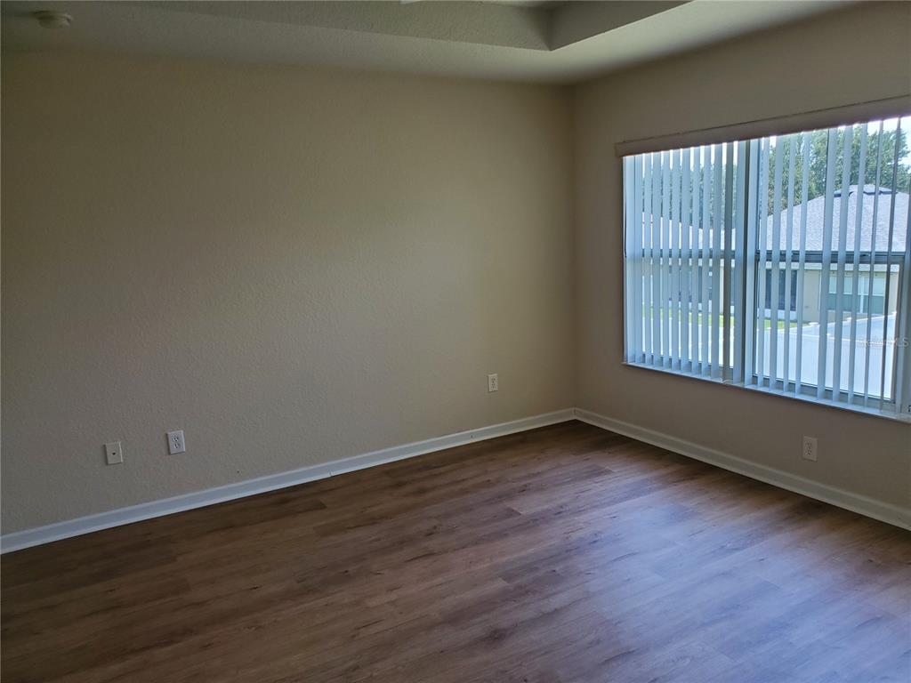 5584 Southwest 39th Street Ocala, FL 34474 - Photo 23 of 56 an empty room with wooden floor and windows
