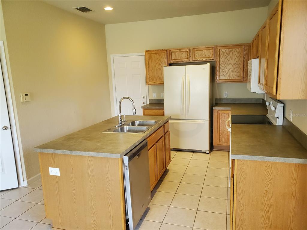 5584 Southwest 39th Street Ocala, FL 34474 - Photo 7 of 56 a kitchen with a sink a refrigerator and a stove