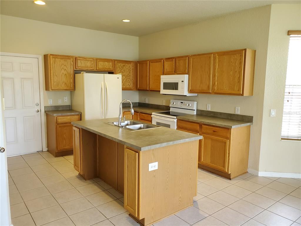 5584 Southwest 39th Street Ocala, FL 34474 - Photo 8 of 56 a kitchen with a sink stove and refrigerator