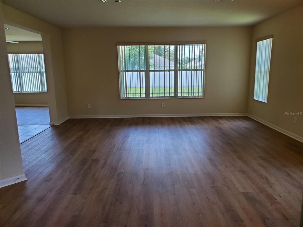5584 Southwest 39th Street Ocala, FL 34474 - Photo 9 of 56 a view of an empty room with wooden floor and a window
