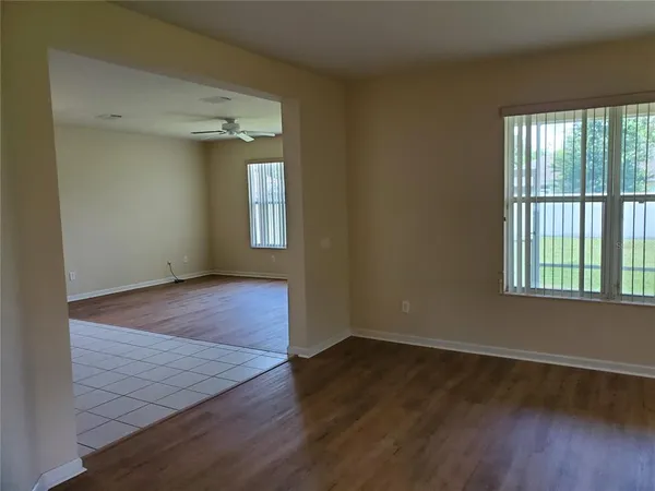 a view of a hallway with wooden floor and a living room