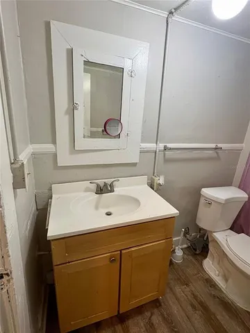 a bathroom with a sink a toilet a mirror and shower