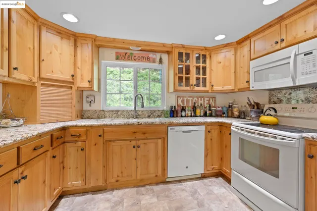 a kitchen with granite countertop a sink stainless steel appliances and cabinets