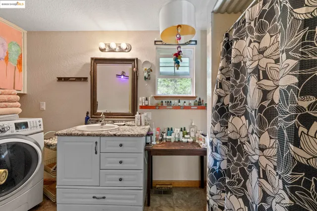 a bathroom with a granite countertop sink and a mirror