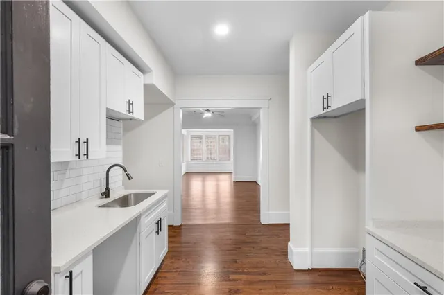 a hallway with wooden floor and windows