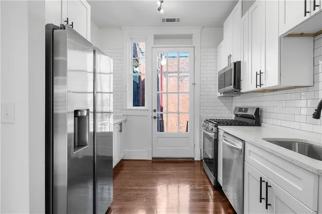 a kitchen with stainless steel appliances granite countertop a refrigerator and a sink