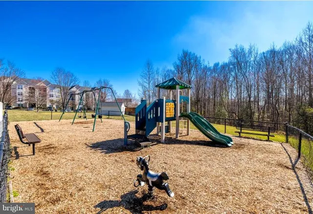 a view of swimming pool with a bench and trees in the background