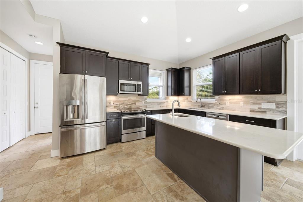 4604 North Fort Christmas Road Christmas, FL 32820 - Photo 13 of 41 a kitchen with stainless steel appliances granite countertop a refrigerator a stove a sink and a microwave
