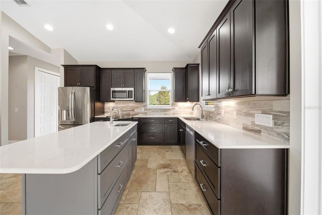 4604 North Fort Christmas Road Christmas, FL 32820 - Photo 14 of 41 a large kitchen with stainless steel appliances granite countertop a sink a stove and a refrigerator