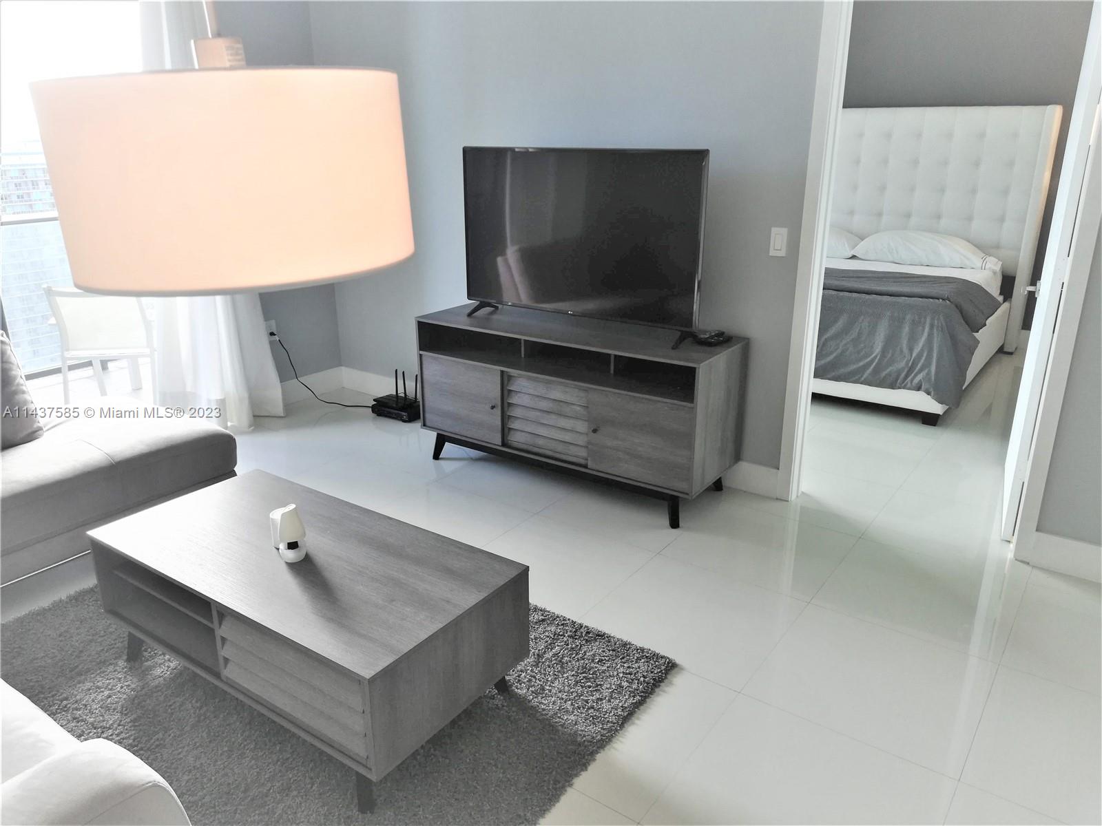 45 Southwest 9th Street, Unit 4004 Miami, FL 33130 - Photo 13 of 23 a living room with furniture and a flat screen tv
