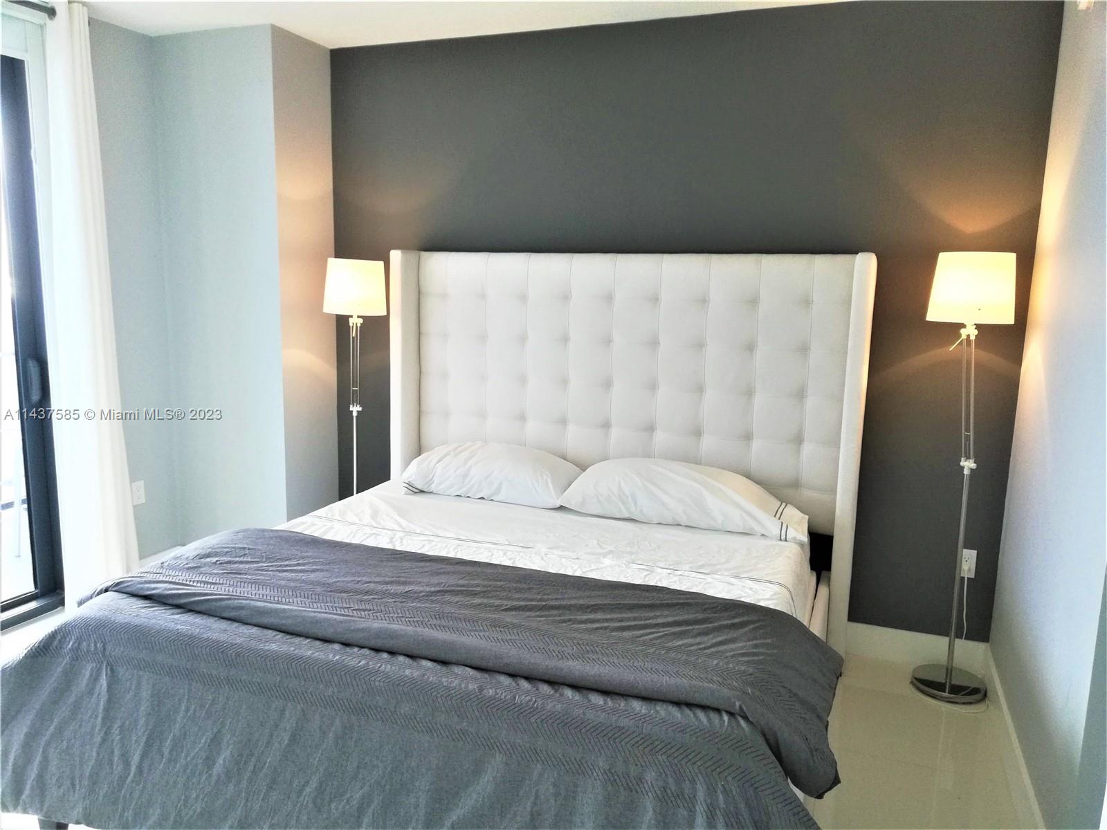 45 Southwest 9th Street, Unit 4004 Miami, FL 33130 - Photo 17 of 23 a bedroom with a bed and a mirror
