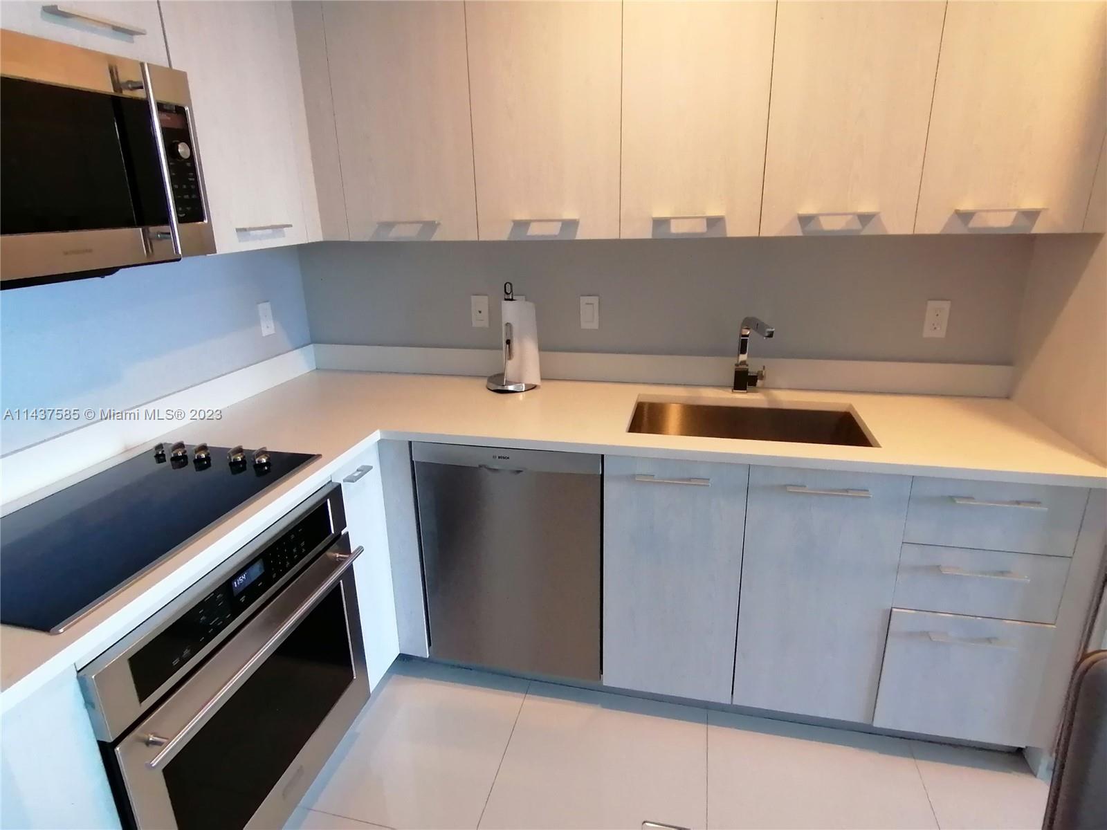 45 Southwest 9th Street, Unit 4004 Miami, FL 33130 - Photo 10 of 23 a kitchen with a sink and a stove