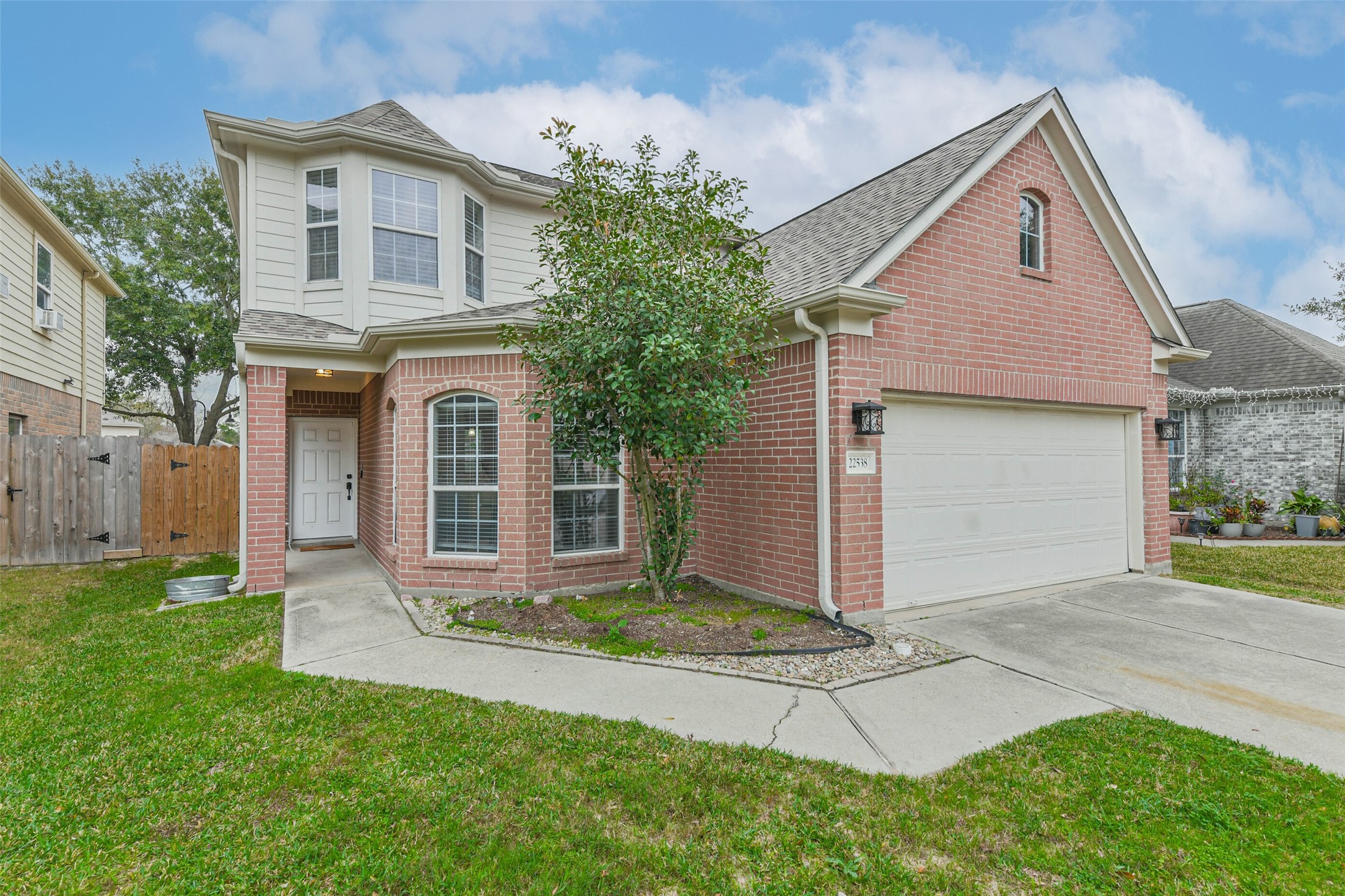 22538 Goss Spring Court Spring, TX 77373 - Photo 2 of 36 This charming two-story home features a red brick exterior with a bay window and a neatly landscaped front yard. It has a spacious driveway leading to a two-car garage, offering plenty of parking space. The entrance is inviting, with a covered porch and well-maintained greenery.