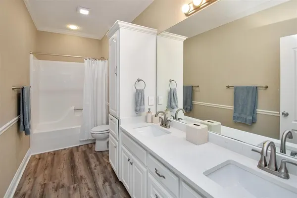 a bathroom with a double vanity sink mirror double and bathtub