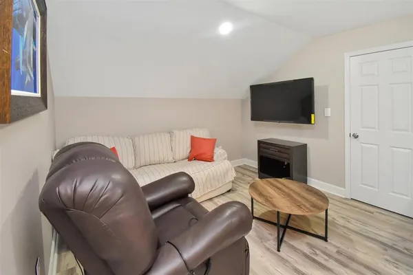 a living room with furniture a flat screen tv and a fireplace