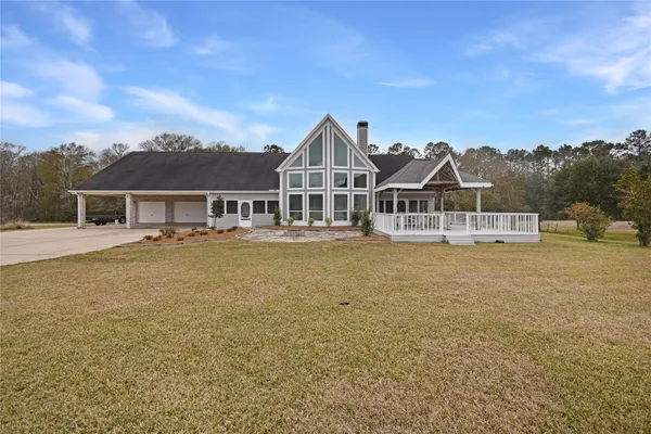 a front view of a house with a garden and lake view