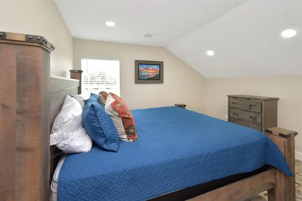 a bedroom with a bed and a painting on the wall