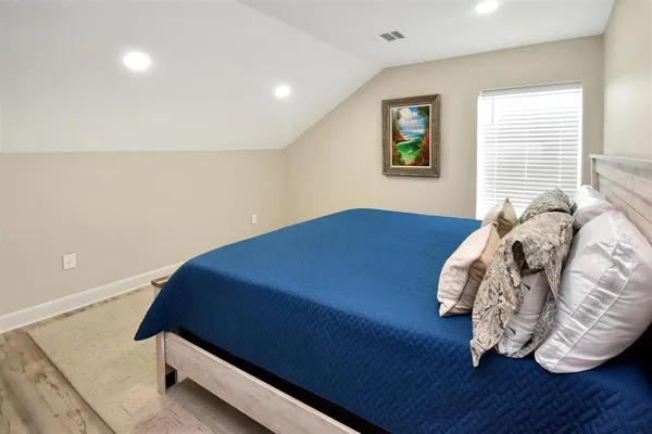 a bed sitting in a bedroom next to a window