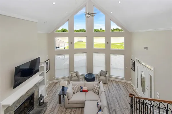 a living room with furniture a flat screen tv and a large window