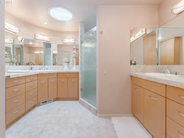 a bathroom with a granite countertop sink a mirror and shower