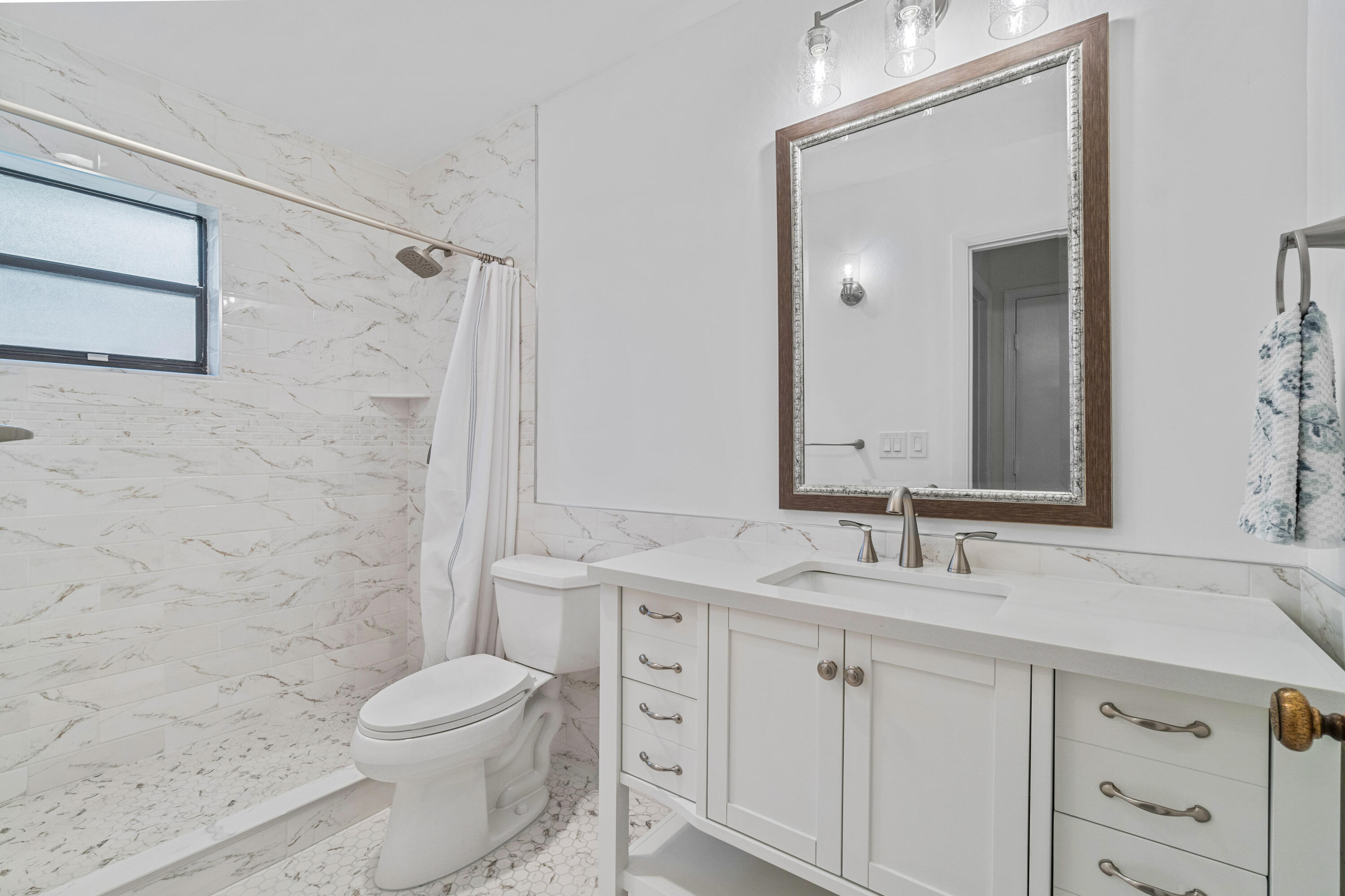 4635 Apple Tree Circle, Unit A Boynton Beach, FL 33436 - Photo 14 of 34 a bathroom with a double vanity sink toilet and shower