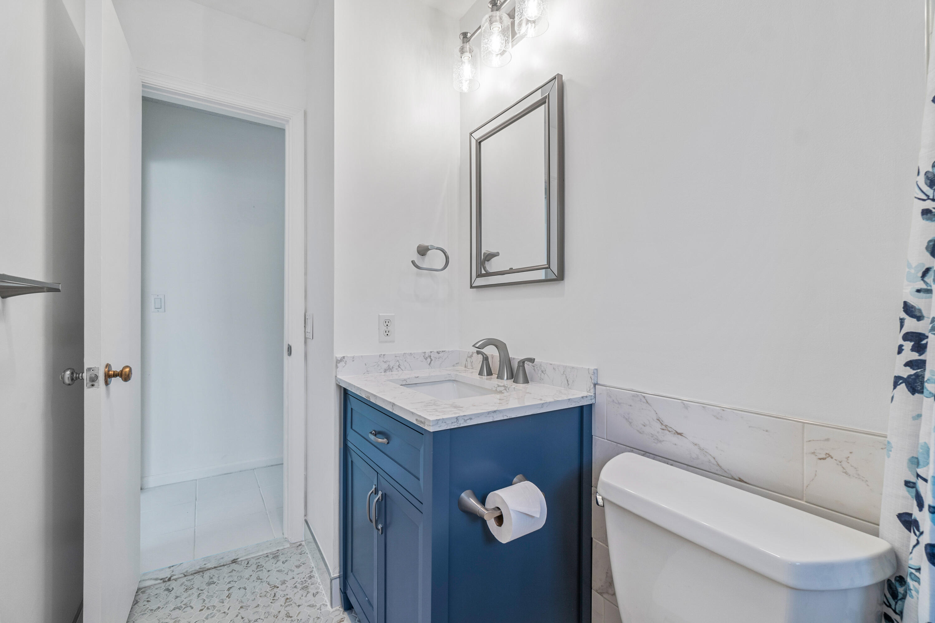 4635 Apple Tree Circle, Unit A Boynton Beach, FL 33436 - Photo 20 of 34 a bathroom with a toilet sink vanity and mirror