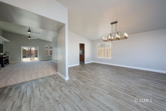 1221 Andrea Court Ridgecrest, CA 93555 - Photo 10 of 50 an empty room with wooden floor and windows