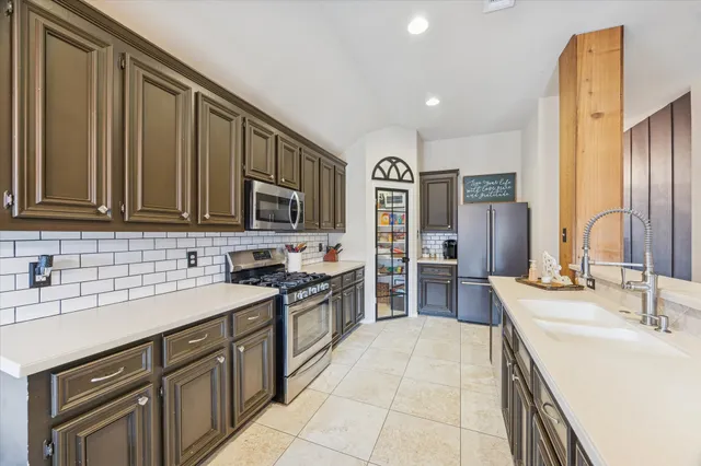 a large kitchen with a large counter top stainless steel appliances and cabinets