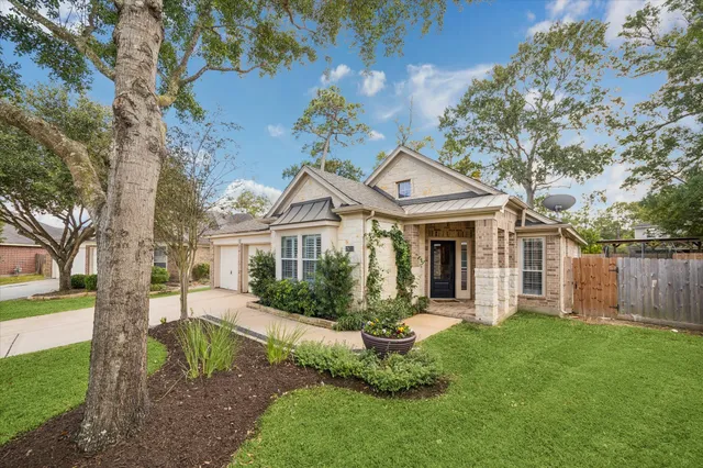 a front view of a house with a yard and potted plants